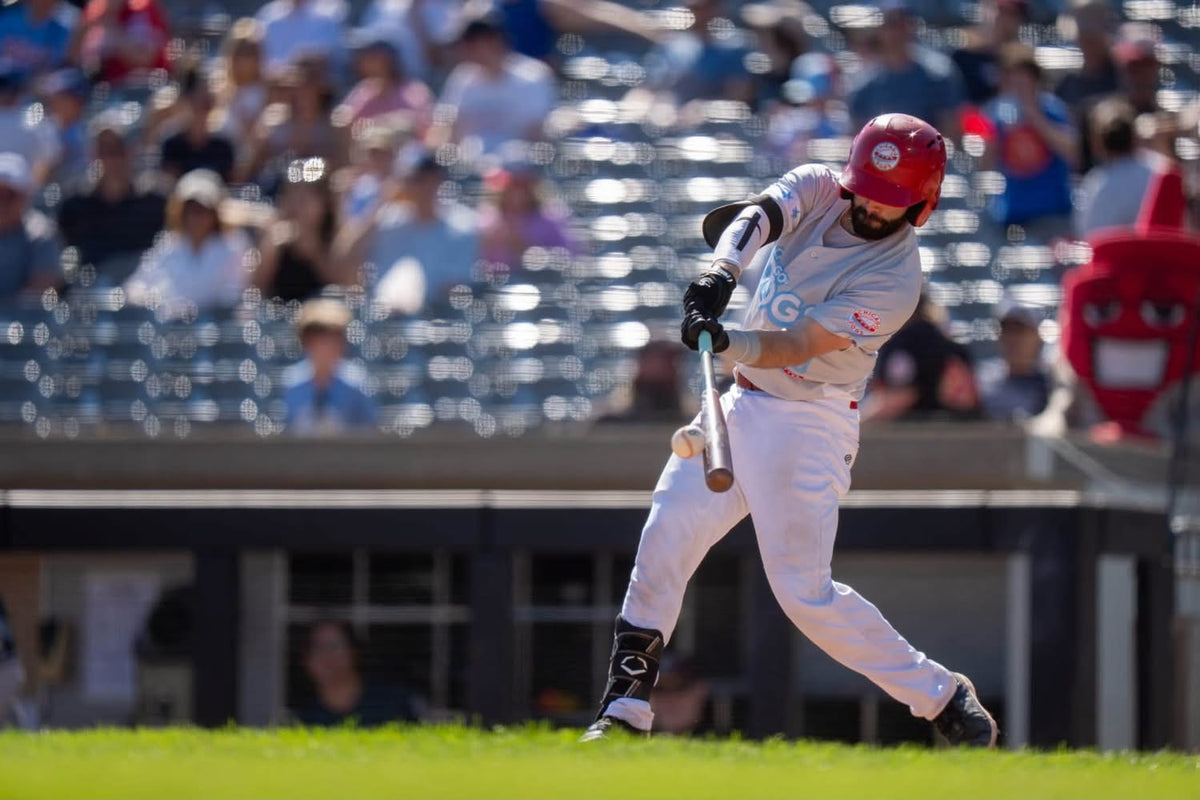 Baseball player swinging a bat while wearing ProSway gloves